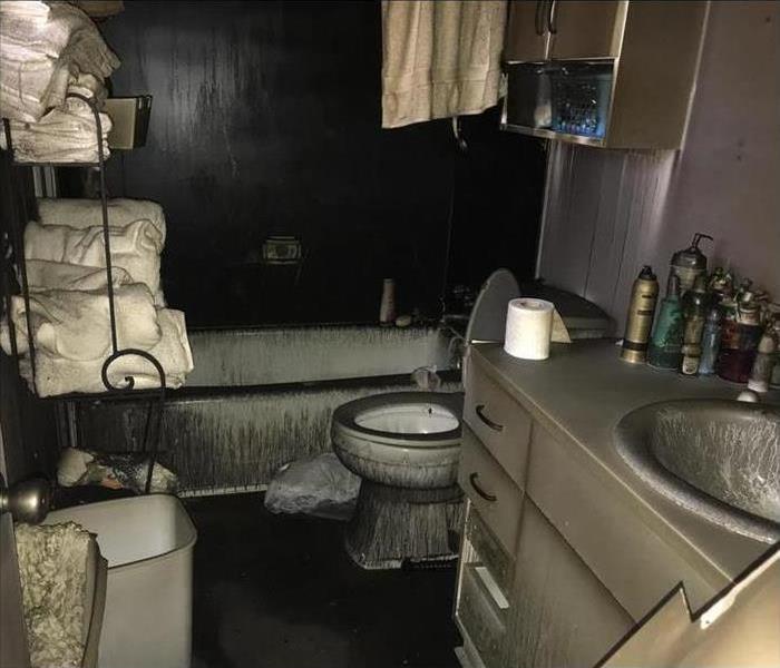 soot covers the surfaces of a bathroom after a fire